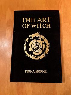 the art of witch book sitting on top of a wooden table