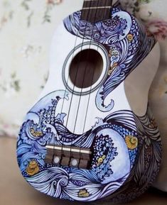 the ukulele is decorated with an intricate blue and white design on it's body