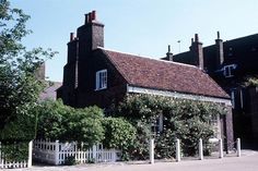 an old brick building with white picket fence around it