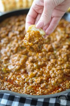 a person dipping some food into a skillet