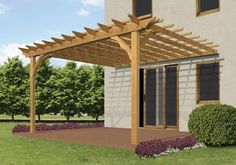 a pergolated covered patio area in front of a house with flowers and shrubs