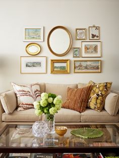 a living room filled with lots of furniture and pictures on the wall above it's coffee table