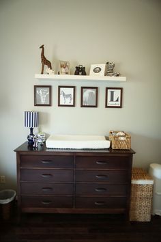 a baby's crib in the corner of a room with pictures on the wall