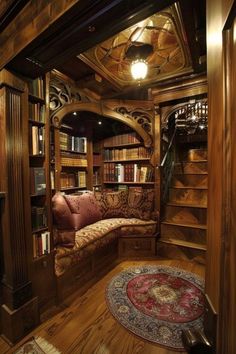 a room that has some bookshelves and a couch inside of it with a rug on the floor