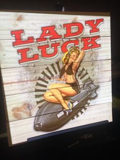 a wooden sign advertising lady luck with a pin up girl on the front and back