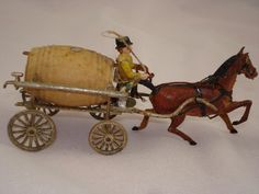 a toy horse and buggy with a man riding on it's back in front of a white background