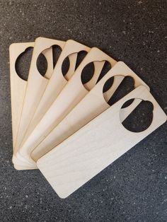 five wooden cutting boards with holes in them on the ground, one is empty and four are not