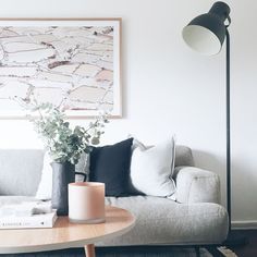 a living room filled with furniture and a painting on the wall above it's coffee table