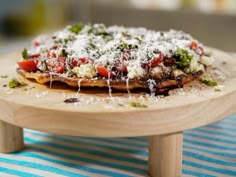 a pizza sitting on top of a wooden plate covered in cheese and toppings,