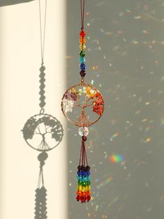 a wind chime hanging from the side of a white wall next to a window