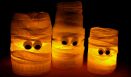 three lit candles with faces on them sitting next to each other in front of a black background