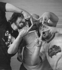 three men making the peace sign with their hands