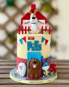 a birthday cake decorated to look like a house with dogs and cats on the front