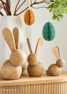 three wooden rabbits sitting next to each other