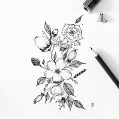 a black and white drawing of flowers on a sheet of paper next to a pen