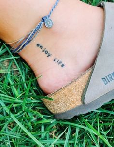 a woman's foot with the words, enjoy life written on it and an ankle bracelet