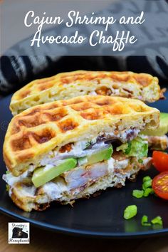 a waffle sandwich cut in half on a black plate with tomatoes and green onions