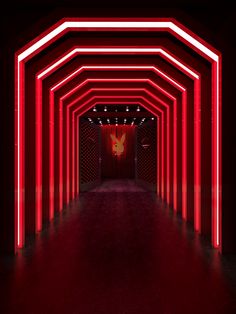 an empty hallway with red neon lights on the walls