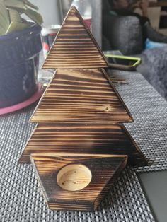 a small wooden christmas tree sitting on top of a table