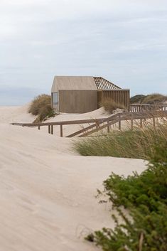 a house on the beach with sand dunes