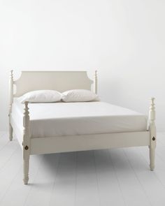 a white bed sitting on top of a hard wood floor