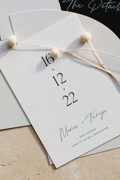 the wedding stationery is laid out on top of two envelopes and tied together with twine