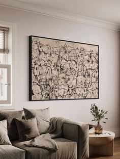 a living room with a couch, coffee table and large painting hanging on the wall