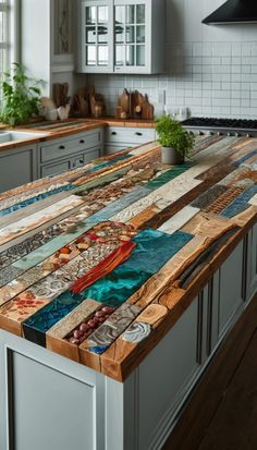 a kitchen island made out of wooden planks and glass tiles with colorful designs on the top