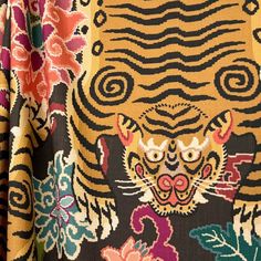 a close up of a tiger on a black and yellow background with colorful florals