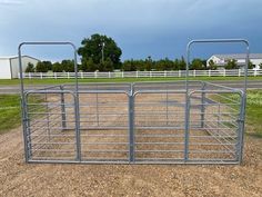 a metal cattle pen sitting on top of a dirt field