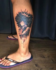 a woman's leg with a tattoo on it and an afro hairdoodle