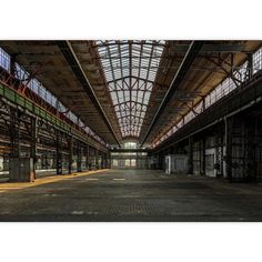 an empty warehouse with lots of windows and steel beams on the ceiling is shown in this image