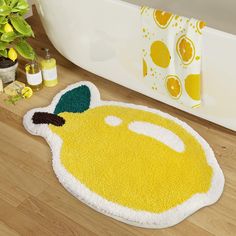 a bath mat with an image of a lemon on it next to a potted plant