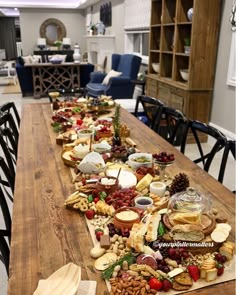 a long table covered in cheese and crackers on top of a hard wood floor