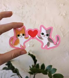 two stickers in the shape of cats with hearts