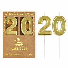 two candles in the shape of numbers are next to a cardboard box that says cake code