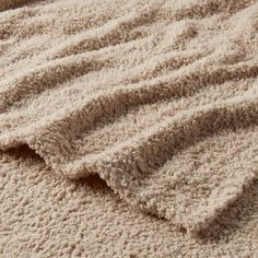 the texture of an area rug is shown in beiges and browns, as well as white