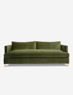 a green velvet sofa against a white background