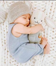 a baby is sleeping with a stuffed animal