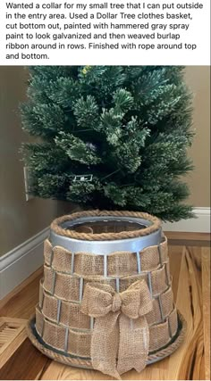 a christmas tree in a burlocked basket with a bow on the bottom