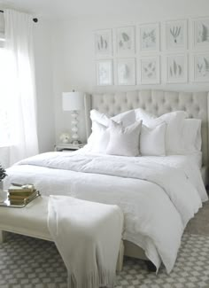 a bed with white linens and pillows in a bedroom