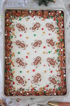 a sheet cake with frosting and decorated gingerbreads