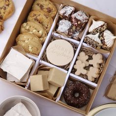 a box filled with lots of different types of cookies and pastries on top of a table