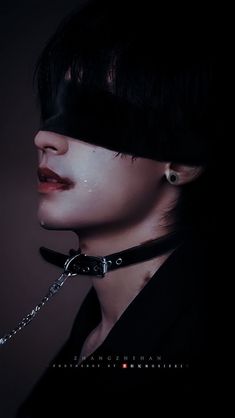 a woman with black makeup and chains on her face