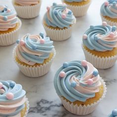 cupcakes with frosting and sprinkles sitting on a marble surface