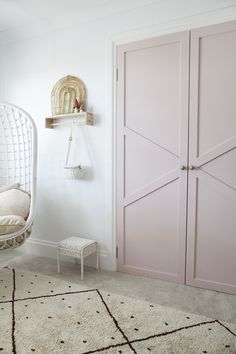 a bedroom with pink closet doors and white rug on the floor in front of it