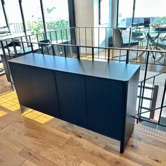 an office desk in the middle of a room with lots of glass doors and railings