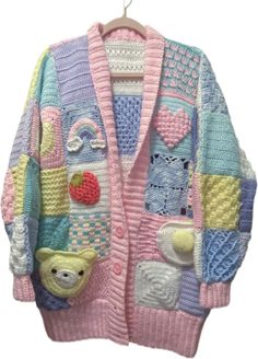 a pink and blue knitted sweater with teddy bears on the front, two different colors