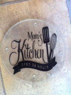 a glass sign that says mom's kitchen open 24 hours