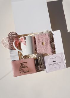 a pink box containing a coffee mug, wallets and other items